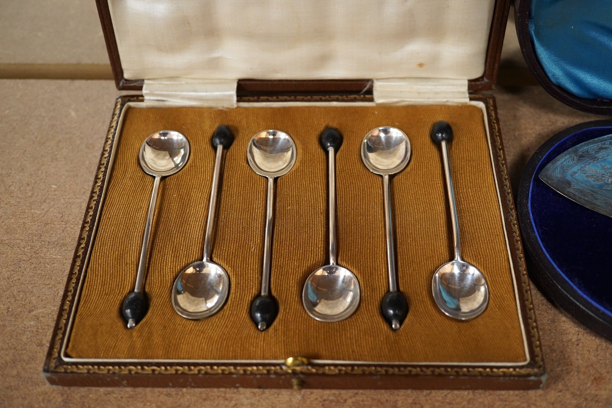 A cased set of six George V silver bean end coffee spoons and a cased pair of silver plated fish servers. Condition - fair